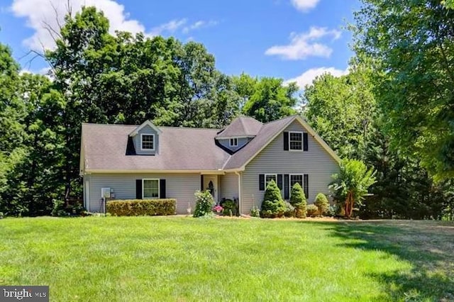 cape cod home featuring a front yard