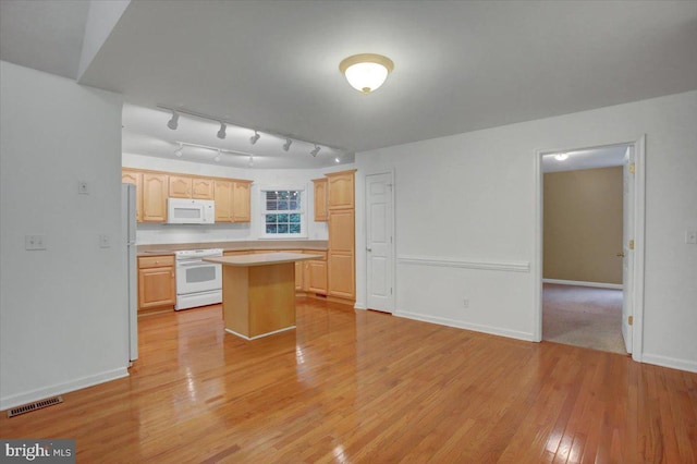 kitchen featuring a center island, light hardwood / wood-style flooring, white appliances, and light brown cabinets