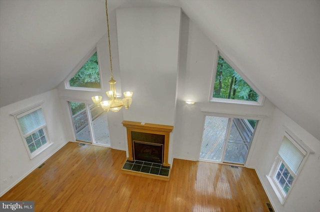 unfurnished living room with a chandelier, hardwood / wood-style floors, and a towering ceiling