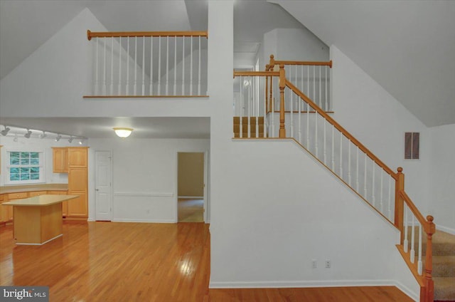 staircase with hardwood / wood-style flooring and vaulted ceiling