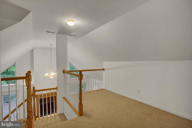 bonus room featuring carpet flooring, vaulted ceiling, and a notable chandelier