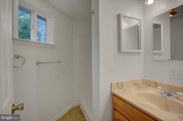 bathroom featuring tile patterned flooring, vanity, and walk in shower