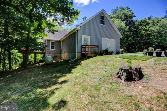 rear view of house featuring a lawn and a garage