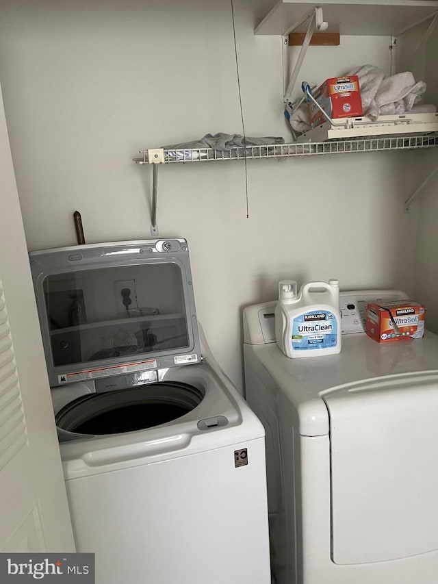 clothes washing area with washing machine and dryer