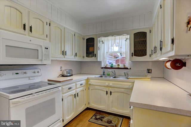 kitchen featuring white appliances, light hardwood / wood-style flooring, and sink