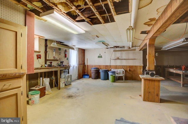 basement with a workshop area and wooden walls