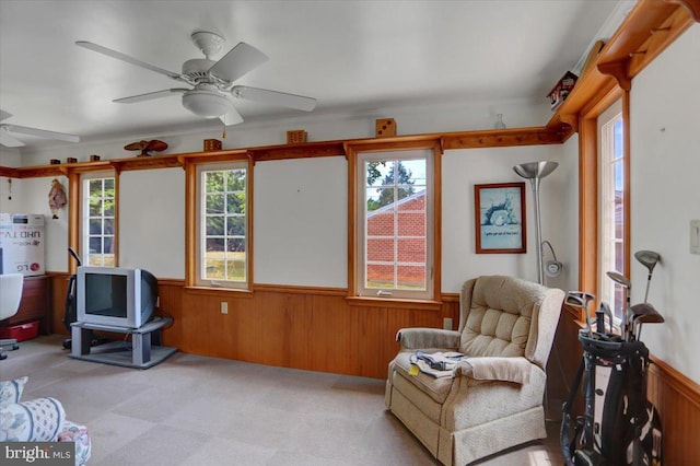 interior space with ceiling fan and wooden walls