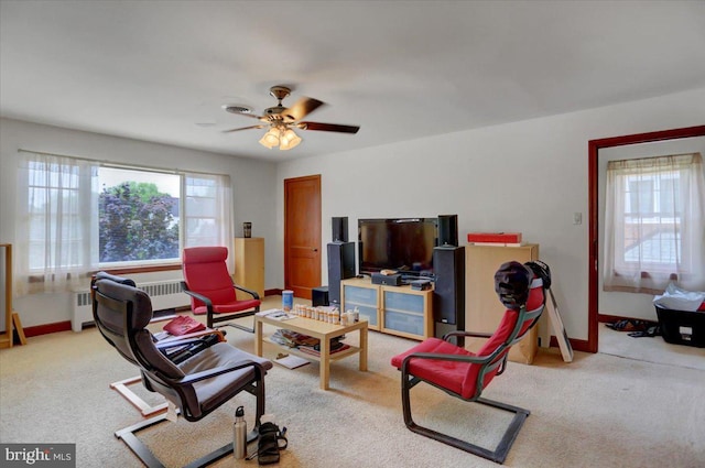 living room featuring light carpet, radiator heating unit, and ceiling fan