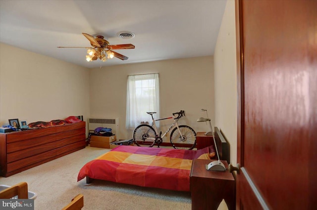 carpeted bedroom featuring ceiling fan and radiator heating unit