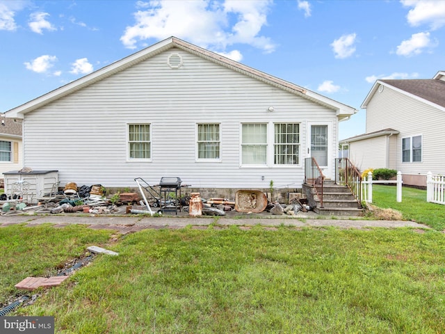 rear view of house featuring a yard