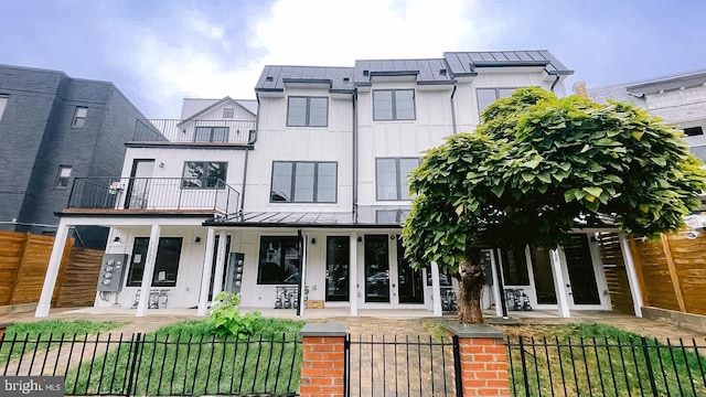 view of front of property featuring covered porch, a balcony, and french doors