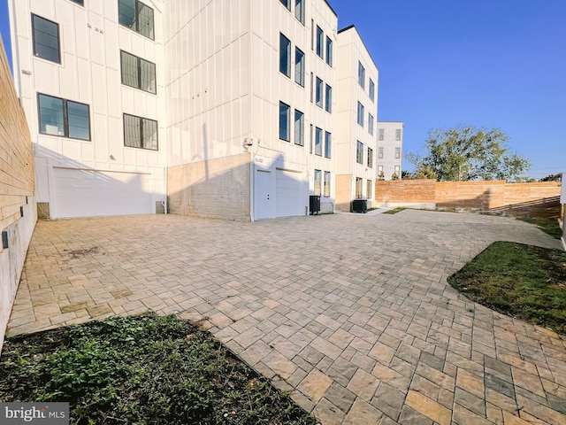 view of building exterior with a garage and central air condition unit