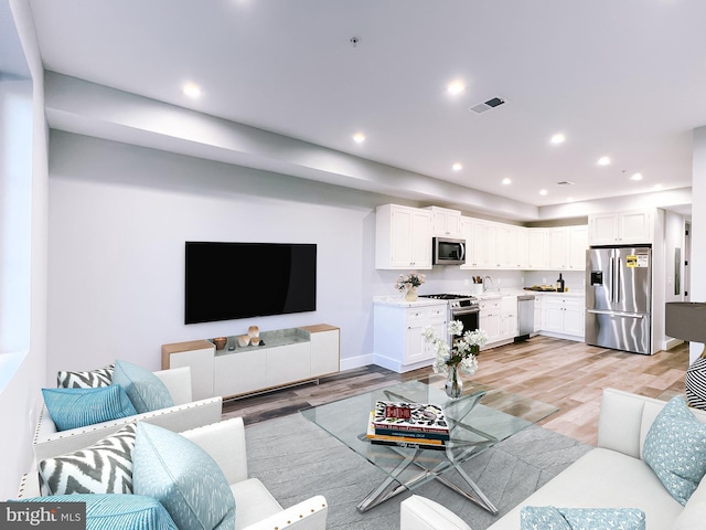 living room featuring light wood-type flooring and sink