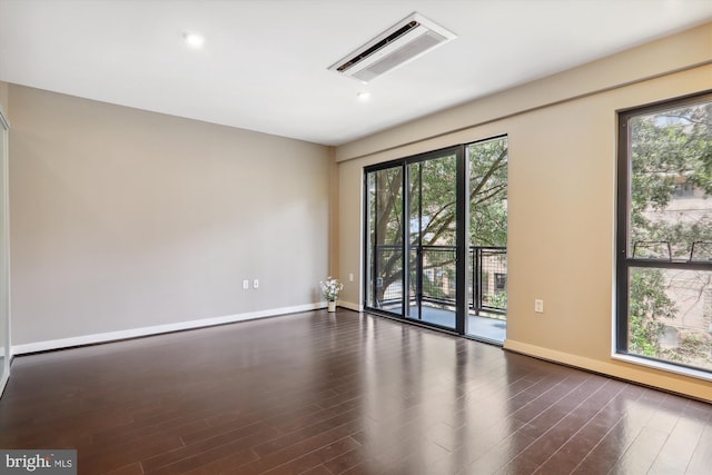 unfurnished room featuring plenty of natural light and dark wood-type flooring