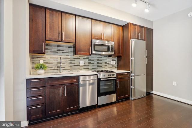 kitchen with dark hardwood / wood-style flooring, decorative backsplash, sink, and stainless steel appliances