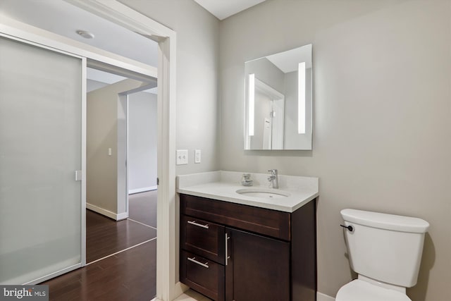 bathroom featuring vanity, hardwood / wood-style flooring, and toilet