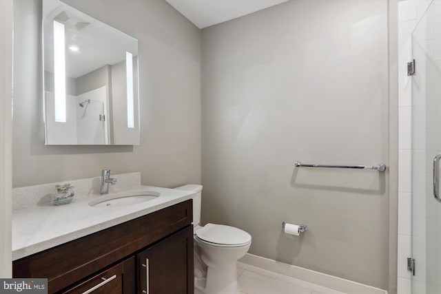 bathroom with tile patterned floors, vanity, a shower with shower door, and toilet