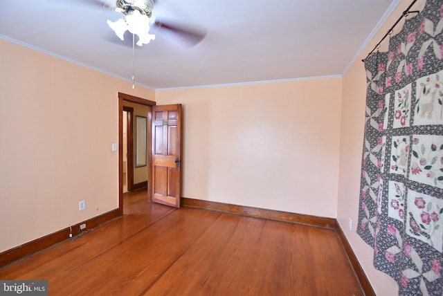 empty room with crown molding, hardwood / wood-style floors, and ceiling fan