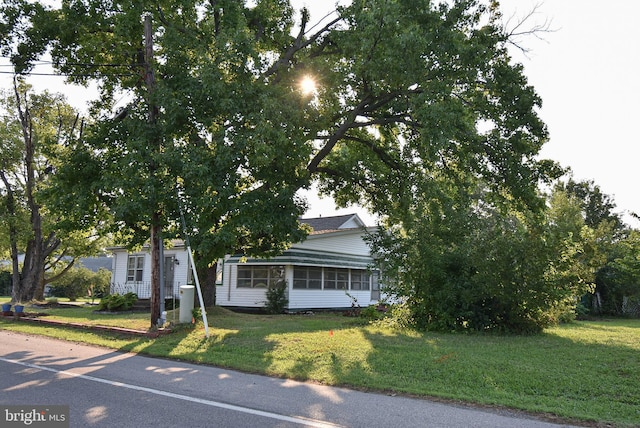 view of property hidden behind natural elements with a front lawn