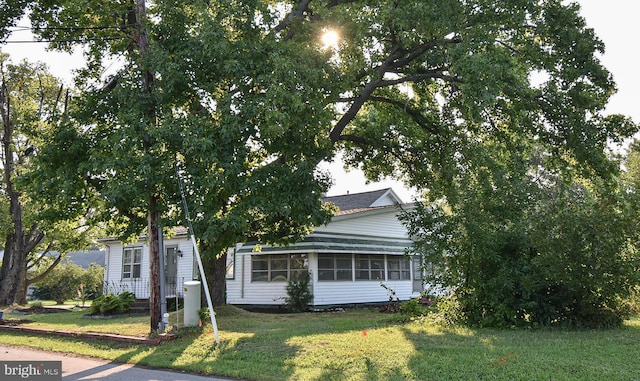 view of property hidden behind natural elements with a front yard