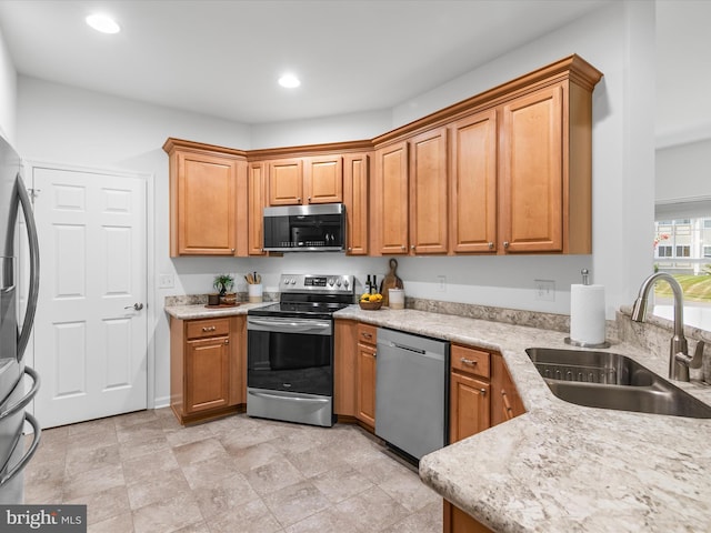 kitchen featuring light stone countertops, sink, and stainless steel appliances