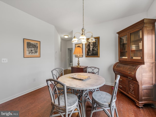 dining room with vaulted ceiling, dark wood-type flooring, and a notable chandelier