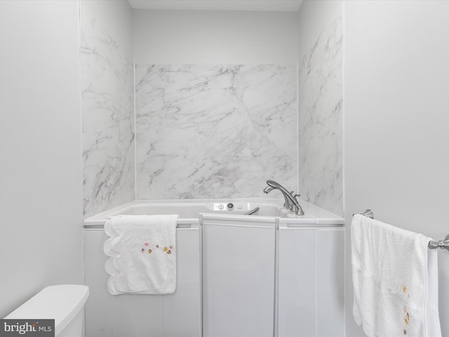 bathroom featuring toilet and a tub