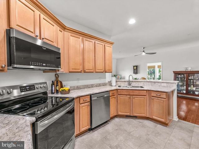 kitchen featuring kitchen peninsula, ceiling fan, sink, and stainless steel appliances