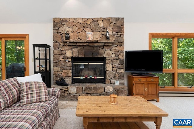 carpeted living room with a fireplace, a healthy amount of sunlight, and a baseboard heating unit