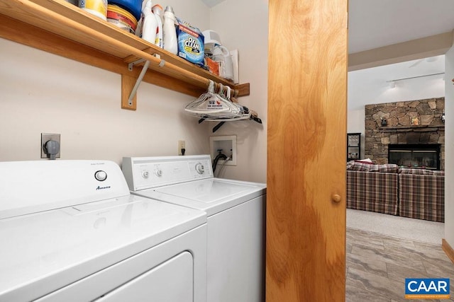 washroom featuring washing machine and dryer and a stone fireplace