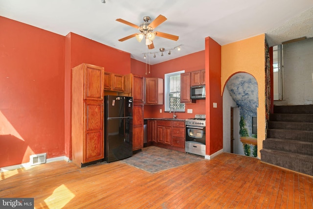 kitchen featuring black appliances, ceiling fan, sink, and light hardwood / wood-style floors