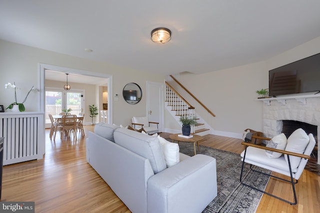 living room with a fireplace and light wood-type flooring