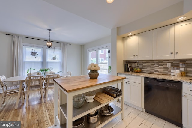 kitchen featuring white cabinets, black dishwasher, tasteful backsplash, and hanging light fixtures