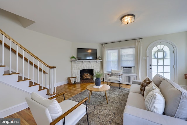 living room with a fireplace, hardwood / wood-style floors, and radiator