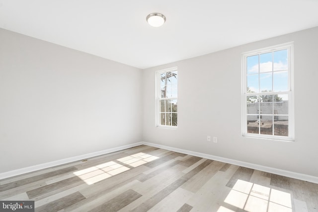 spare room featuring a wealth of natural light and light hardwood / wood-style floors