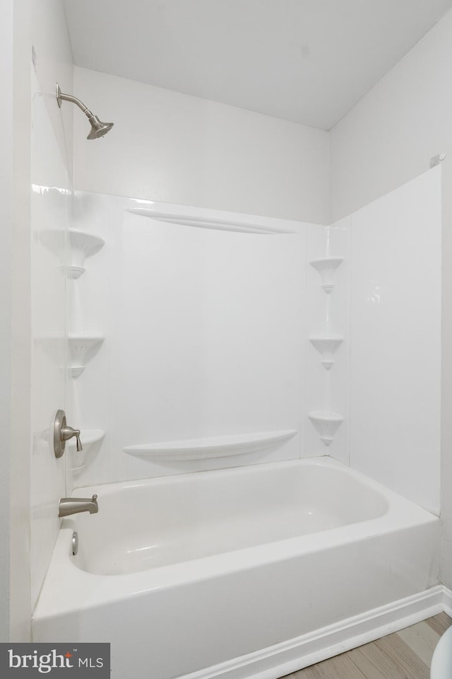 bathroom with shower / washtub combination and hardwood / wood-style flooring