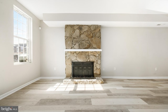 unfurnished living room featuring a fireplace and light hardwood / wood-style flooring