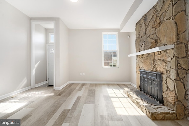 unfurnished living room with a fireplace and light hardwood / wood-style flooring