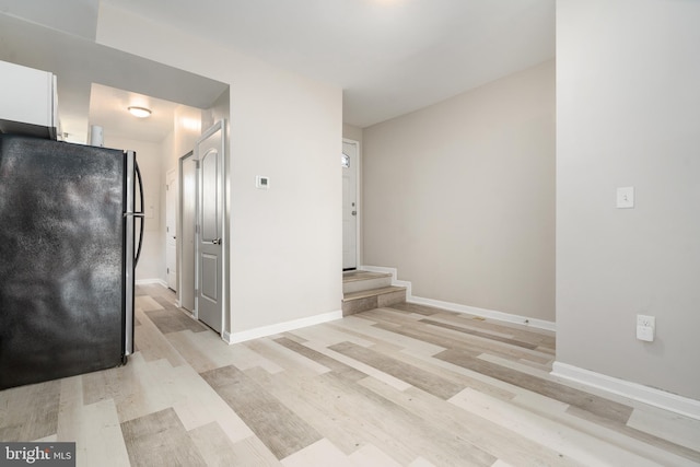 kitchen with black fridge and light hardwood / wood-style floors