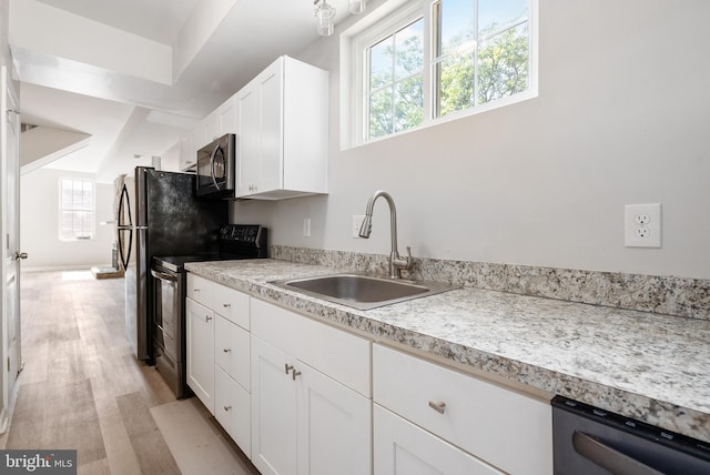 kitchen featuring light wood-type flooring, stainless steel appliances, white cabinetry, and sink