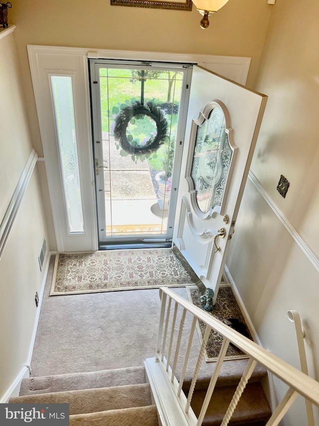 foyer entrance with carpet floors