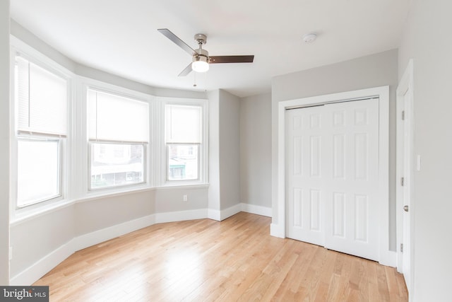 unfurnished bedroom with ceiling fan, a closet, and light hardwood / wood-style floors