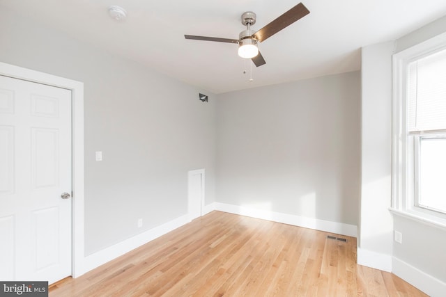 empty room with ceiling fan, a wealth of natural light, and light hardwood / wood-style flooring