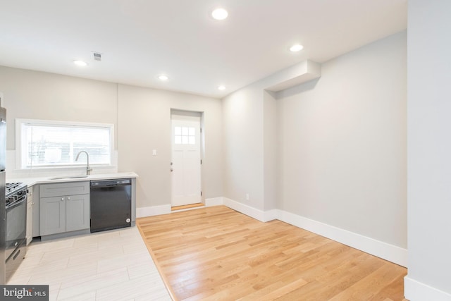 kitchen with light hardwood / wood-style floors, a healthy amount of sunlight, and black appliances