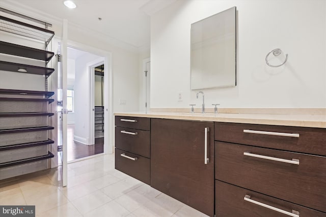 bathroom featuring tile patterned flooring, vanity, and crown molding