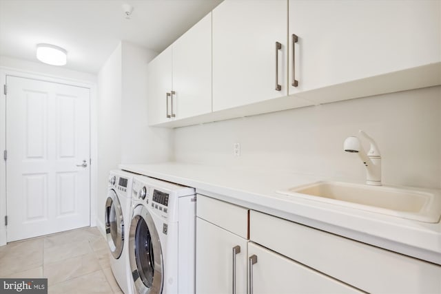 clothes washing area featuring cabinets, independent washer and dryer, sink, and light tile patterned floors