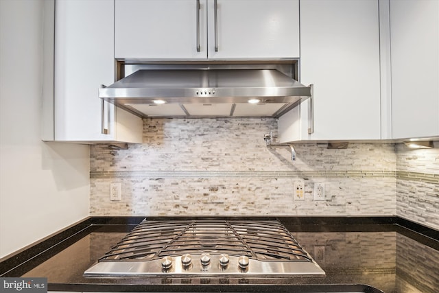 kitchen featuring white cabinets, decorative backsplash, and wall chimney range hood