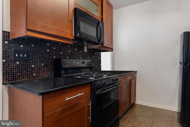 kitchen with backsplash, dark tile patterned floors, and black appliances