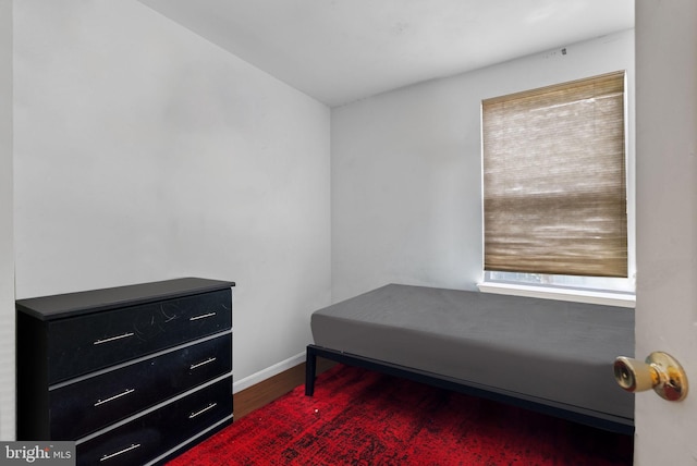 bedroom with multiple windows and dark wood-type flooring