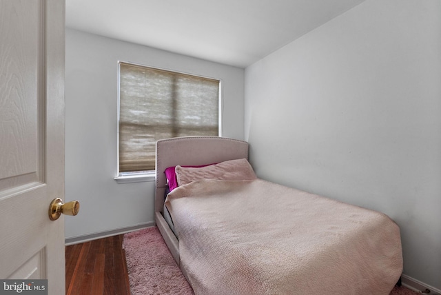 bedroom with multiple windows and dark wood-type flooring